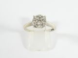 a close up of a diamond ring on a white surface