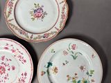 four plates with floral designs are arranged on a gray surface