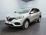une voiture argentée garée dans un garage, près d'un mur blanc