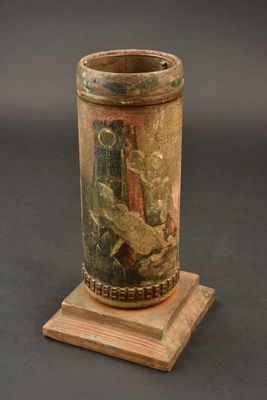 un vase orné d'une peinture, posé sur un socle en bois