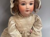 an antique doll sitting on a table with a hat on