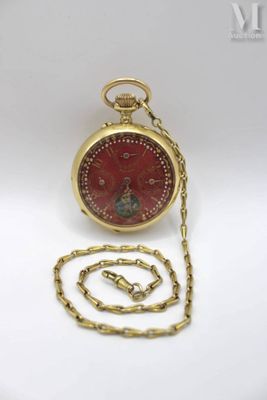a red pocket watch with a gold chain on a white surface
