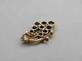 a close up of a gold brooch on a table
