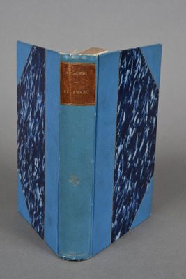 an old book with a blue cover sitting on top of a table