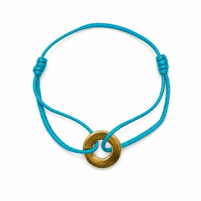 un bracelet composé d'un anneau en laiton monté sur un cordon bleu