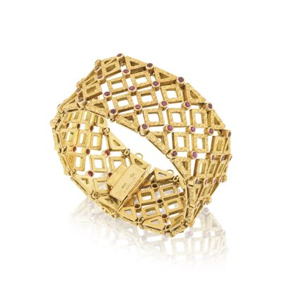 gros plan d'un bracelet en or sur fond blanc