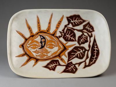 une assiette blanche ornée d'un motif marron et orange