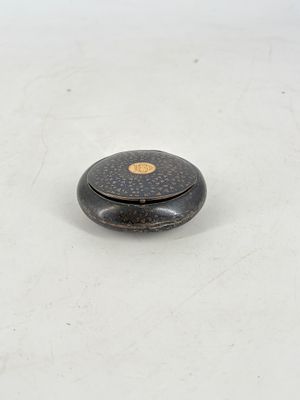 an antique black and gold box sitting on top of a white surface