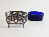 a blue bowl and a silver bowl on a white surface