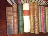 several old books are lined up on a wooden table
