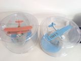 two plastic containers with a toy airplane inside of them