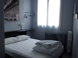 a bed in a small room with a red lamp above it