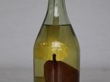 a bottle with a pear inside of it on a table