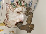 a vase with a bird on it and a faucet on the side