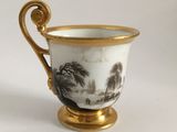 a cup with a handle that has a painting on it