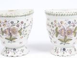 deux vases blancs ornés de motifs floraux, placés l'un à côté de l'autre