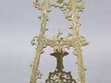 une image représentant une horloge plaquée or posée sur un socle, sur fond blanc