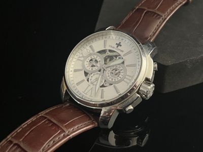 a close up of a watch with a brown leather strap
