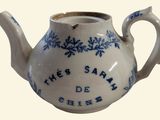 a small tea pot with a blue and white design on it