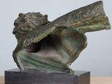 a close up of a bronze sculpture of a man holding a large shell