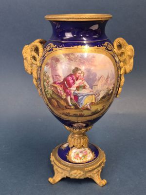 a blue vase with a painting on it sitting on a table