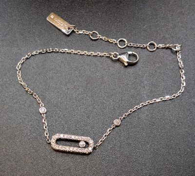 a close up of a silver chain with a diamond pendant on it
