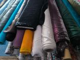 many rolls of fabric on a rack in a room