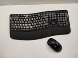 a computer keyboard and a mouse on a desk