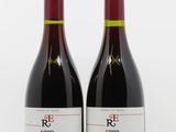deux bouteilles de vin rouge posées l'une à côté de l'autre sur une surface blanche