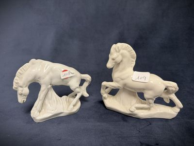 two white ceramic figurines of horses on a blue background