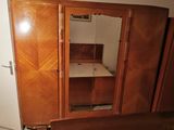 a large wooden cabinet with a mirror on top of it
