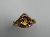 a close up of a ring with a yellow diamond and pink sapphires