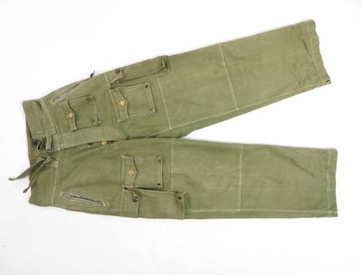 une photo d'un pantalon de treillis militaire posé sur une surface blanche