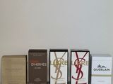 three boxes of perfume sitting next to each other on a white surface