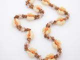 collier de perles avec des coquillages et des perles marron sur un fond blanc