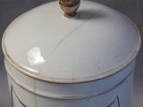 a white canister with a gold lid on a table