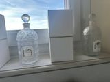 a bottle of alcohol sitting on a window sill next to a box of cigarettes