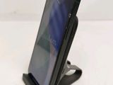 a close up of a cell phone on a stand on a table