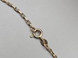 a close up of a gold chain on a white surface