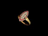 gros plan d'une bague en or avec des pierres rouges et blanches
