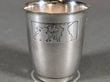 an antique silver cup with a design on the side