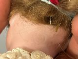 a doll with a red dress and a red bow on it ' s head