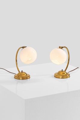 a pair of brass table lamps on a white surface