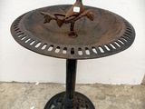 a bird sitting on top of a birdbath on a table