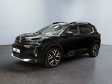 un SUV noir garé dans une pièce aux murs blancs