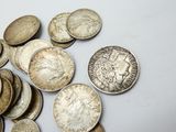 a pile of silver coins on a white surface