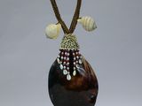a brown vase with shells on it on a stand
