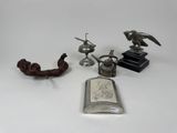 une flasque en argent ornée d'un oiseau et d'autres motifs sur un fond blanc
