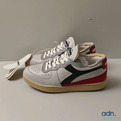 des baskets blanches et rouges avec une bande noire et rouge sur la semelle