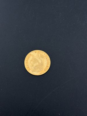 a close up of a gold coin on a black surface